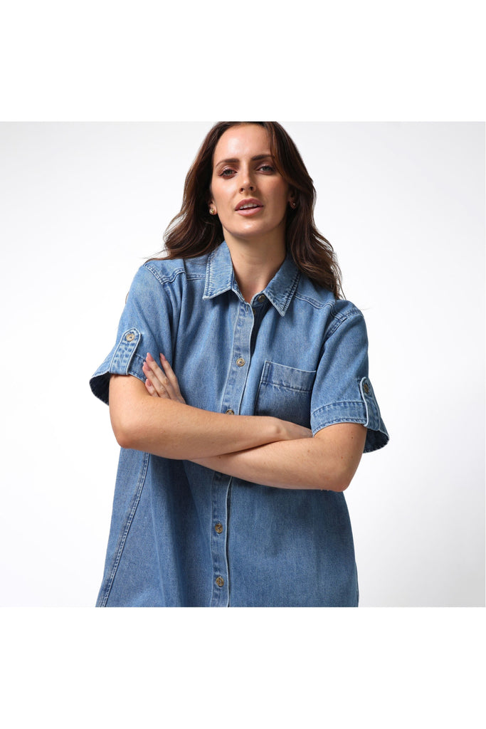 Woman wearing a Stella and Gemma Vinnie Dress in blue denim against a white background
