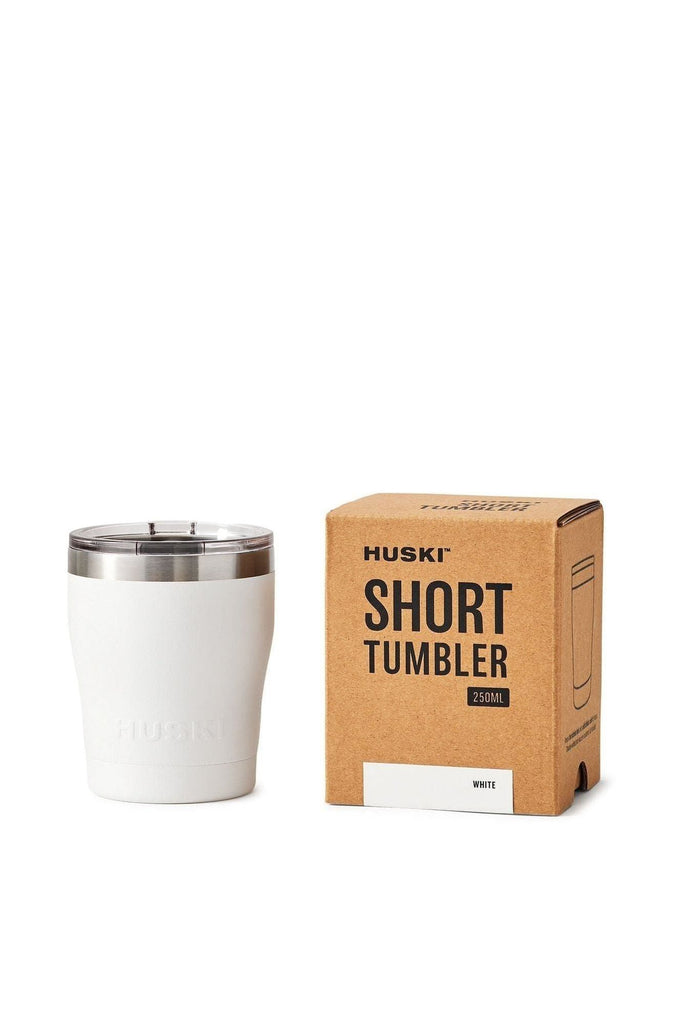 A Huski White tumbler with a silver ring around the top and a clear lid sits next to its packaging box on a white background.