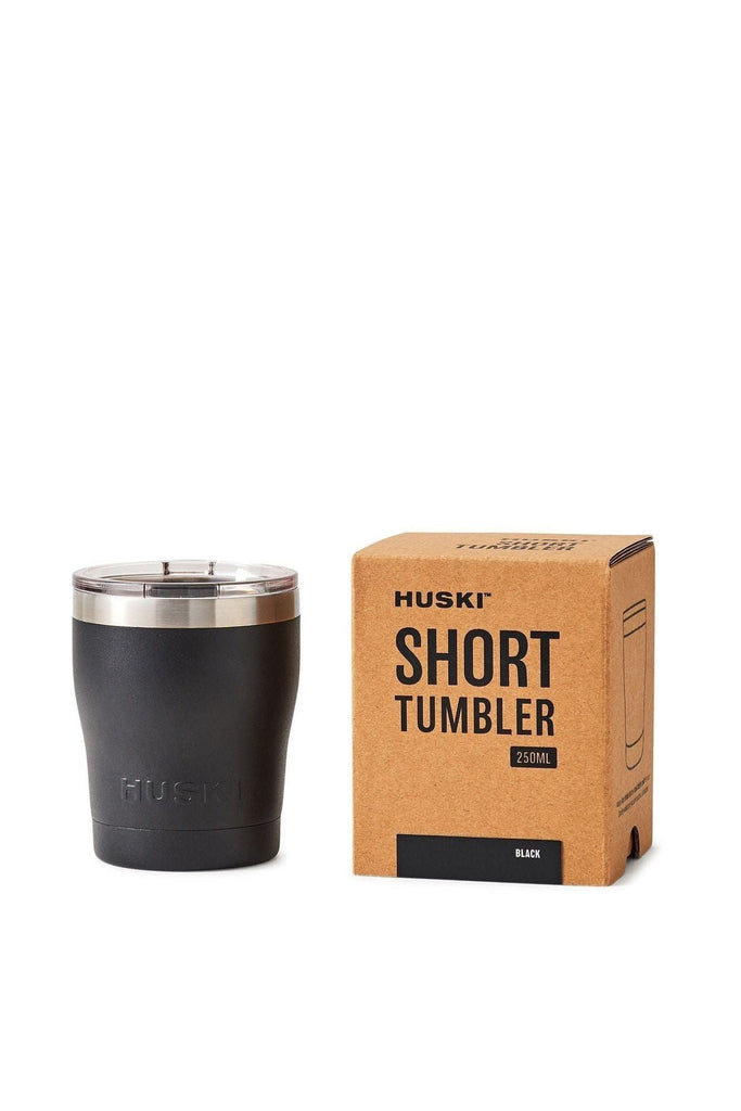 Black Huski tumbler featuring a silver ring around the top, accompanied by a clear lid, next to its packaging box on a white background.