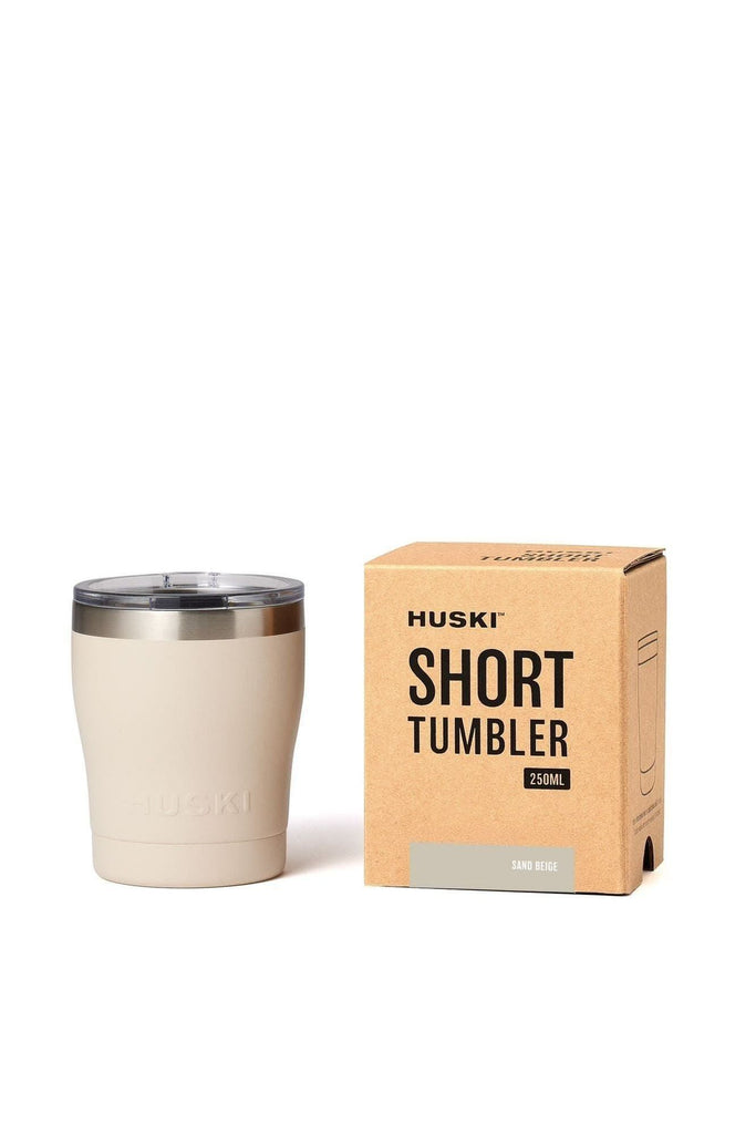 A Huski Short 250ml Sand Beige tumbler with a silver rim next to its packaging box on a white background.