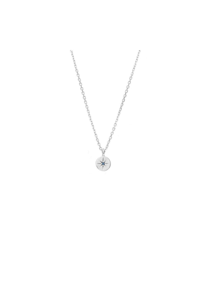 Silver necklace with a small pendant called North Star from New Zealand label Silk & Steel with a blue sapphire gemstone in the middle on a white background