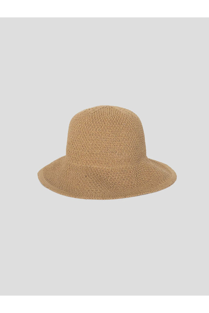 Beige woven hat on a light gray background. Sophie Travelling Hat in natural.