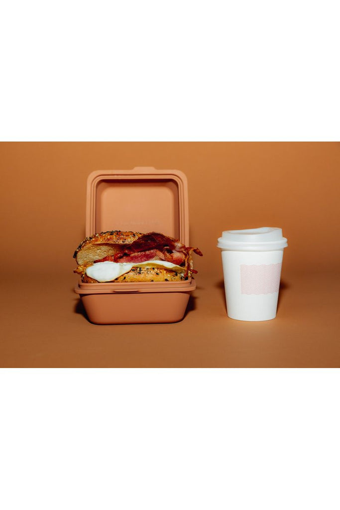 TOGO Sun The Burger Box in Spice. Displayed showing filled with Bacon & Egg Bagel and a takeaway coffee cup standing beside it