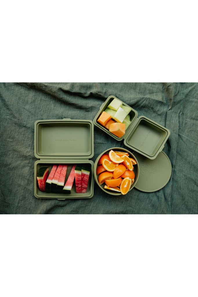 Togo Sun Catcus Takeaway Box, Burger Box and Bowl.  All sitting on a picnic blanket open and displaying food contents.  The Takeaway Box homes watermelon slices, The Burger Box houses melon pieces and The Bowl homes cut up orange wedges.