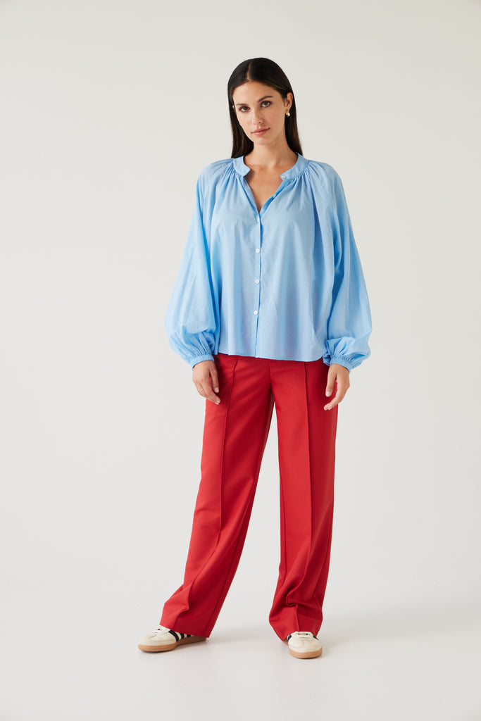 Tuesday Label Pioneer Top, blouse in sky blue on model with base pants in red