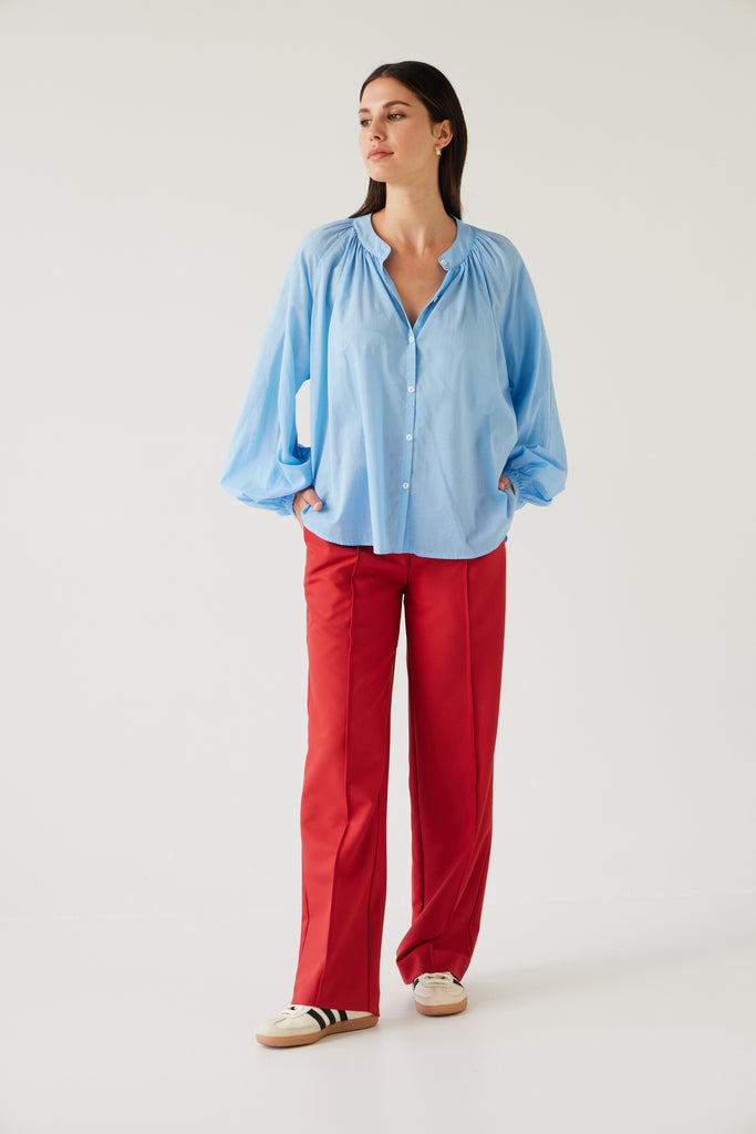 Tuesday Label Pioneer Top, blouse in sky blue on model with cherry red base pant