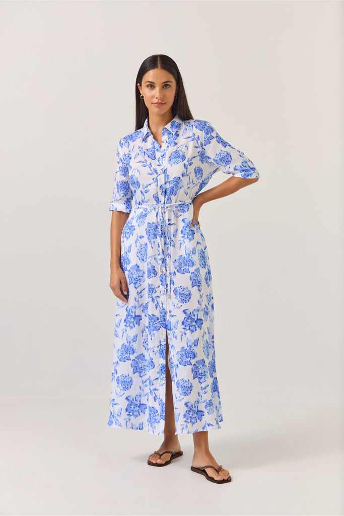 Woman wearing a blue floral dress on a white background. Tuesday Label Nicola dress in Blue Rose. 
