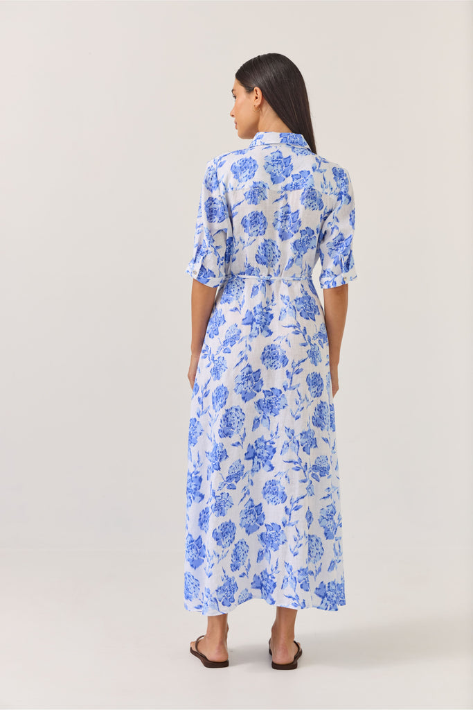 Woman wearing a blue floral dress on a white background. Tuesday Label Nicola dress in Blue Rose. 