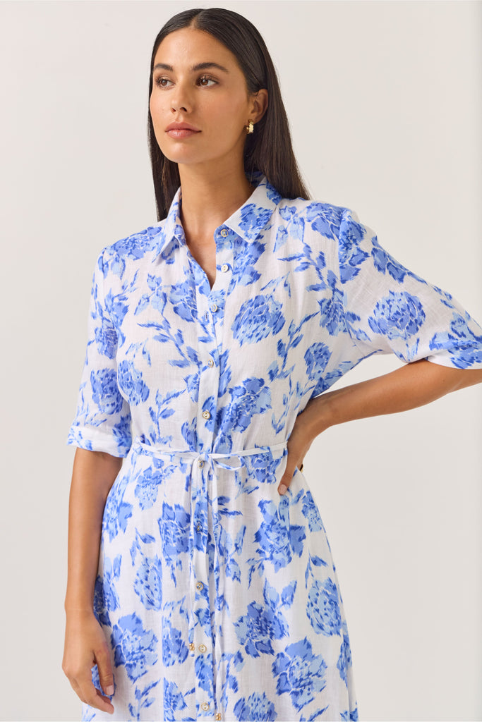 Woman wearing a blue floral dress on a white background. Tuesday Label Nicola dress in Blue Rose. 