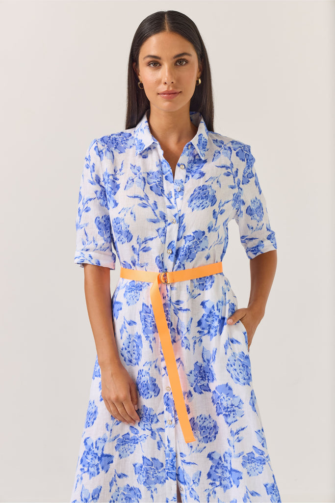 Woman wearing a blue floral dress on a white background. Tuesday Label Nicola dress in Blue Rose. 