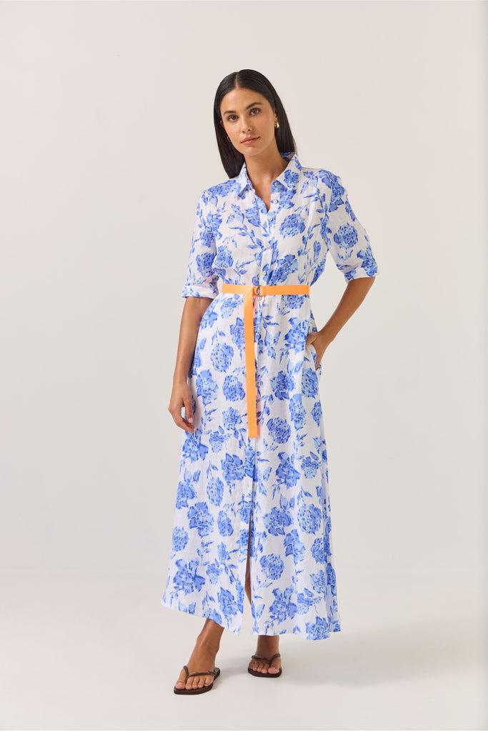 Woman wearing a blue floral dress on a white background. Tuesday Label Nicola dress in Blue Rose. 