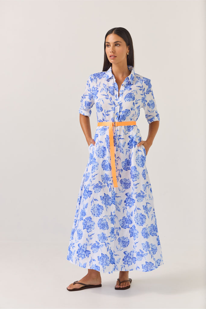 Woman wearing a blue floral dress on a white background. Tuesday Label Nicola dress in Blue Rose. 