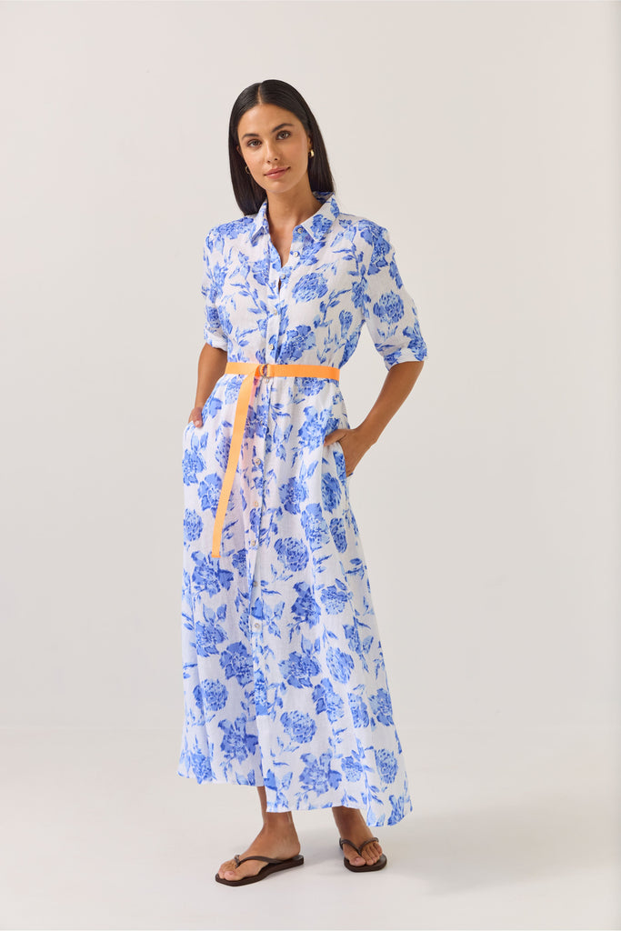 Woman wearing a blue floral dress on a white background. Tuesday Label Nicola dress in Blue Rose. 