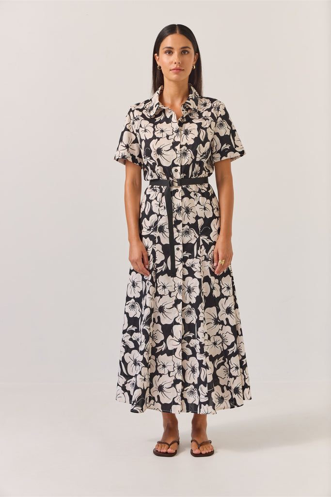 Woman wearing a black and white floral dress on a white background. Tuesday Label Godet Shirt Dress