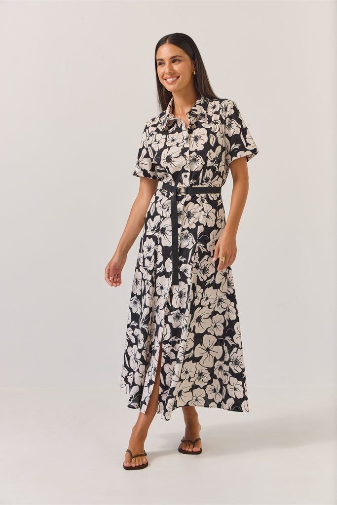 Woman wearing a black and white floral dress on a white background. Tuesday Label Godet Shirt Dress