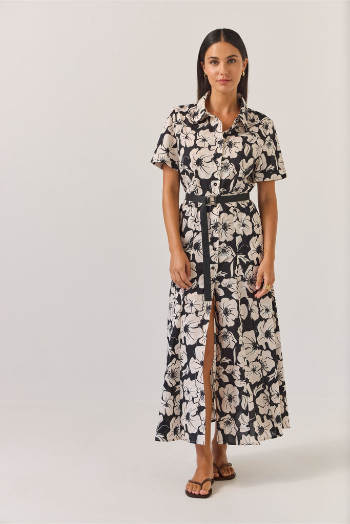 Woman wearing a black and white floral dress on a white background. Tuesday Label Godet Shirt Dress