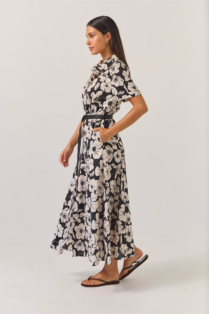 Woman wearing a black and white floral dress on a white background. Tuesday Label Godet Shirt Dress