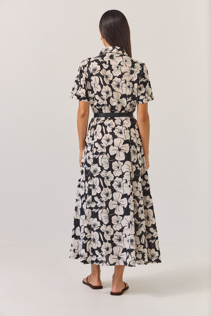 Woman wearing a black and white floral dress on a white background. Tuesday Label Godet Shirt Dress