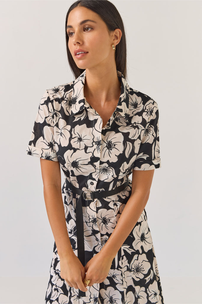 Woman wearing a black and white floral dress on a white background. Tuesday Label Godet Shirt Dress