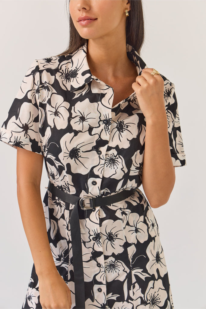 Woman wearing a black and white floral dress on a white background. Tuesday Label Godet Shirt Dress