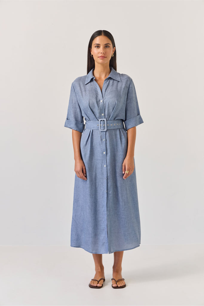 Woman wearing a blue dress with a belt on a white background. Tuesday Label Sunray dress.