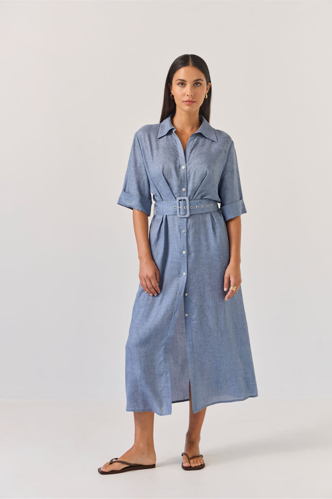 Woman wearing a blue dress with a belt on a white background. Tuesday Label Sunray dress.