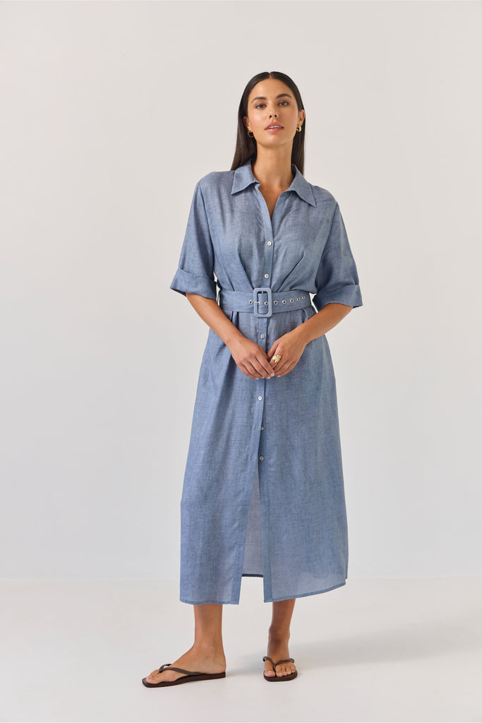 Woman wearing a blue dress with a belt on a white background. Tuesday Label Sunray dress.