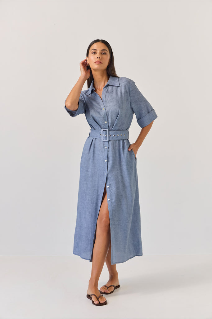 Woman wearing a blue dress with a belt on a white background. Tuesday Label Sunray dress.