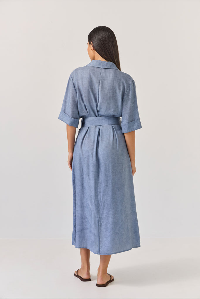 Woman wearing a blue dress with a belt on a white background. Tuesday Label Sunray dress.