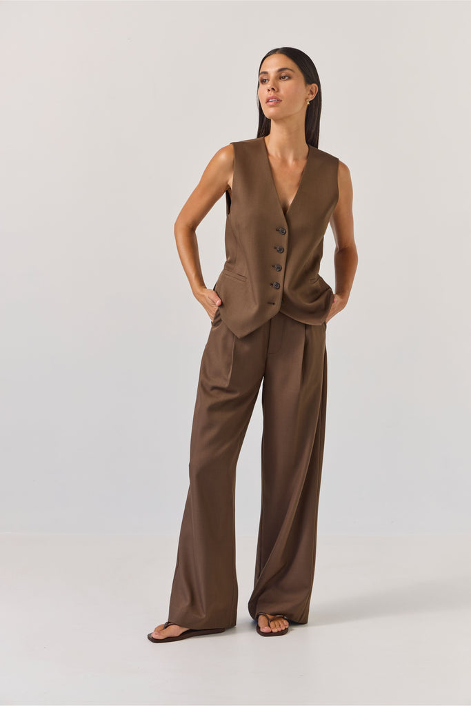 Woman wearing a brown vest and wide-leg pants on a white background. Tuesday Label Boyfriend Pant in Bitter Chocolate with matching vest.