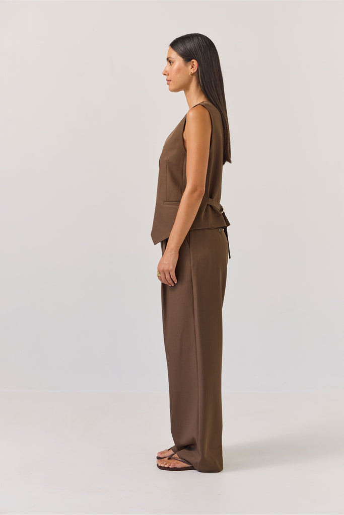 Woman wearing a brown vest and pants set on a white background. Tuesday Label Action Vest and Boyfriend pant in Bitter Chocolate.