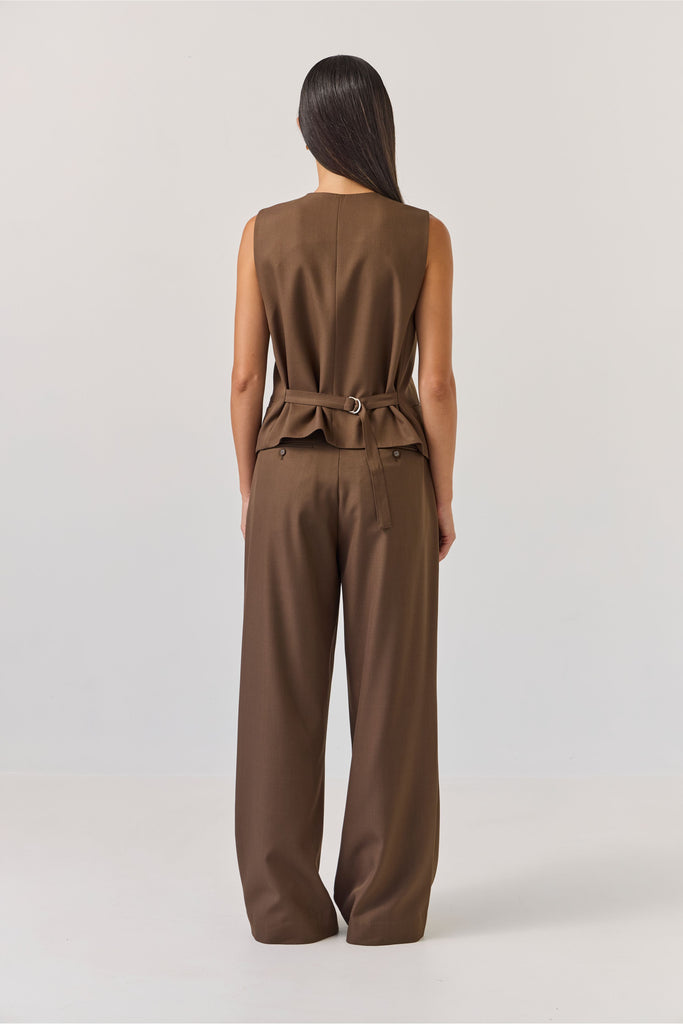 Woman wearing a brown vest and pants set on a white background. Tuesday Label Action Vest and Boyfriend pant in Bitter Chocolate.