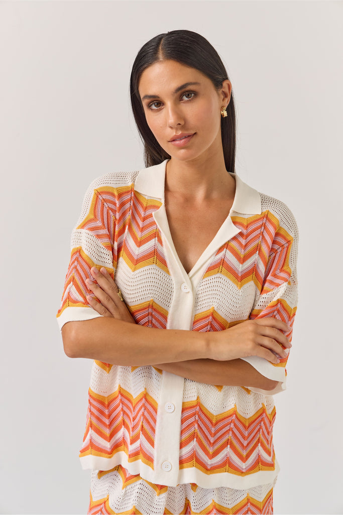 Woman wearing a colourful zigzag chevron patterned top and shorts on a white background. Tuesday Label Revere Top and Umpire Shorts.