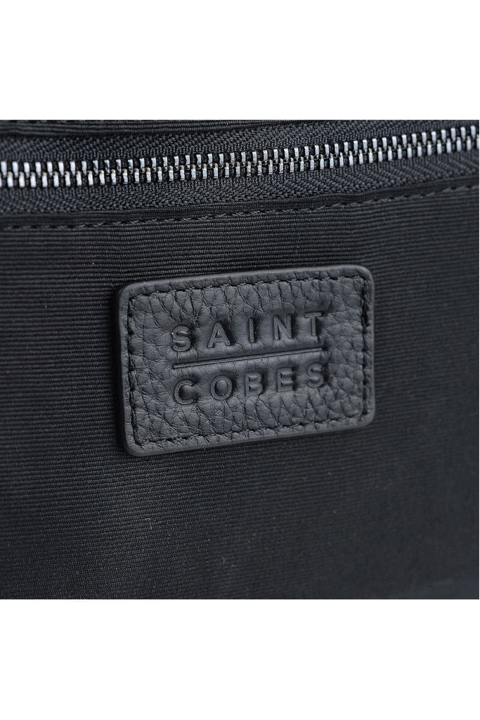 Saint Cobes, Close-up of the waterproof interior with a zipped internal pocket of the black leather toiletry/wash bag with 'Saint Cobes' branding.