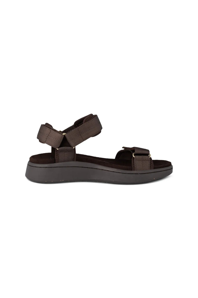 Brown sandal with gold accents on a white background. Woden Line Sandal in Chocolate.