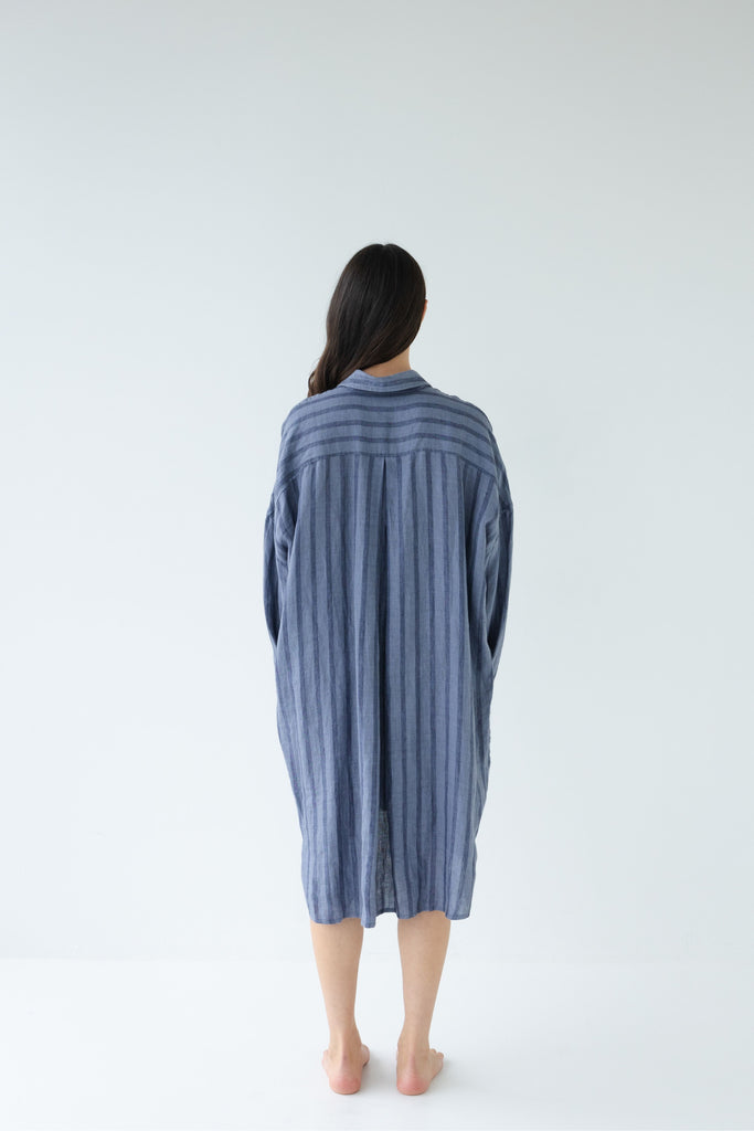 Woman wearing a blue striped shirt dress on a white background. Sophie Always Shirt dress in Denim Stripes.
