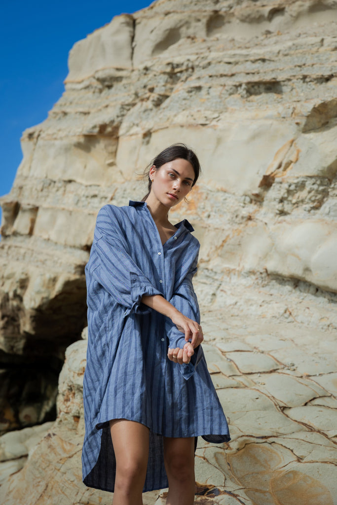 Woman wearing a blue striped shirt dress at the beach. Sophie Always Shirt dress in Denim Stripes.