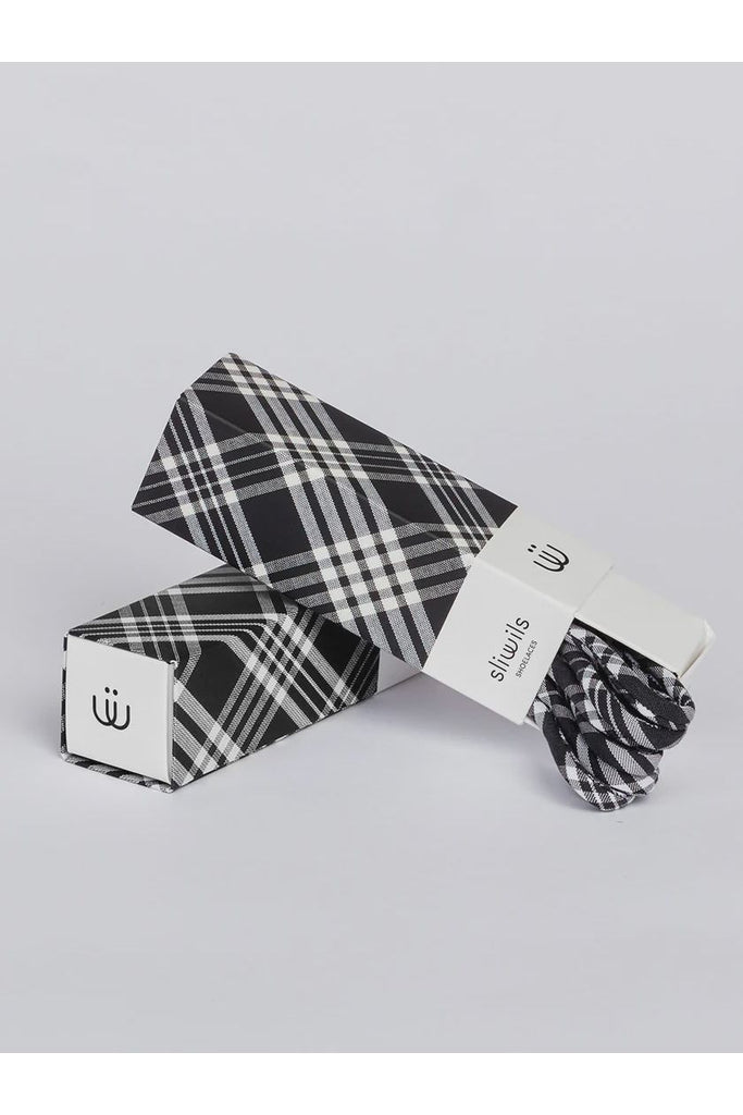 Black and white plaid shoelaces with packaging on a light gray background