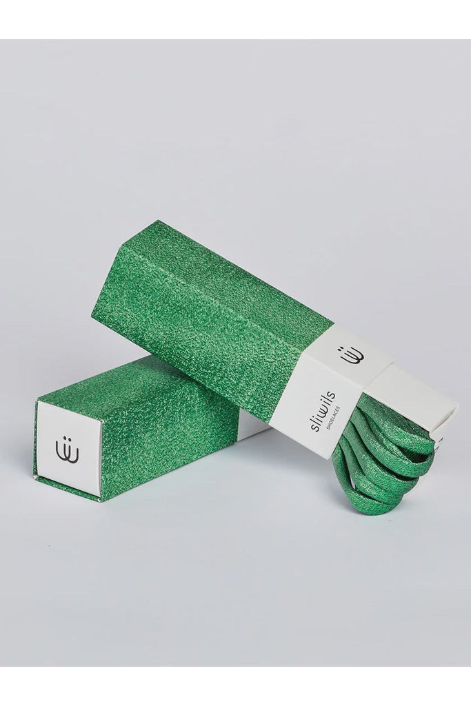 Green glittery shoelaces with packaging on a light grey background