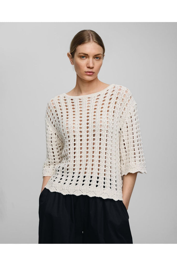 Woman wearing an off white crochet top against a gray background. MSCH Copenhagen Fairyn Top.