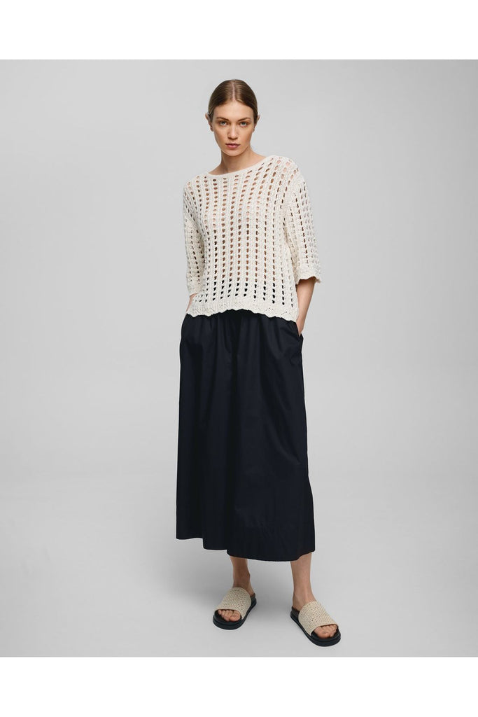 Woman wearing an off white crochet top against a gray background. MSCH Copenhagen Fairyn Top.