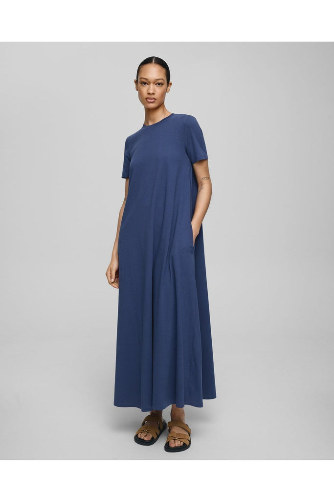 Woman wearing a blue dress on a grey background. MSCH Copenhagen Olga Organic SS dress in Oceana Blue