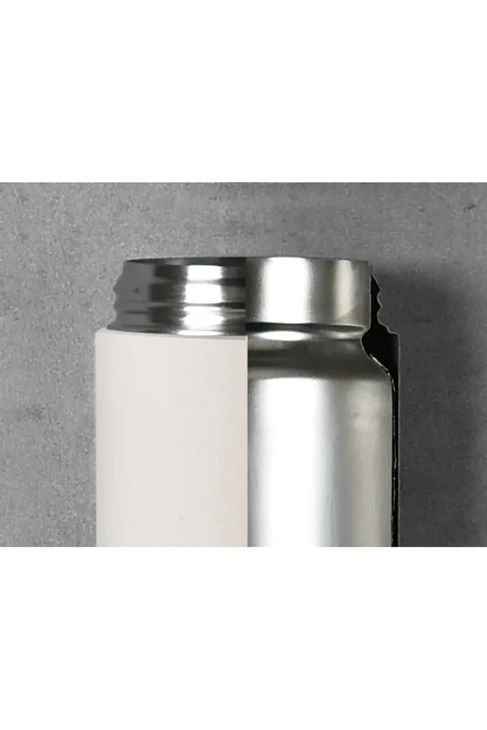 Kinto Day Off Insulated Tumbler. This tumbler features a close-up cross-section that highlights its double-walled stainless steel construction. The design includes a vacuum between the inner and outer walls to prevent heat transfer. Additionally, a foil layer on the inner wall reflects heat inside, which enhances both heat retention and cold retention.