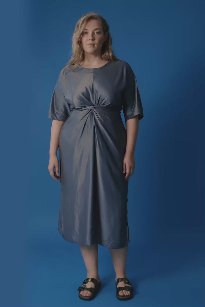 Woman wearing a gray dress on a blue background. Elk Lissu dress