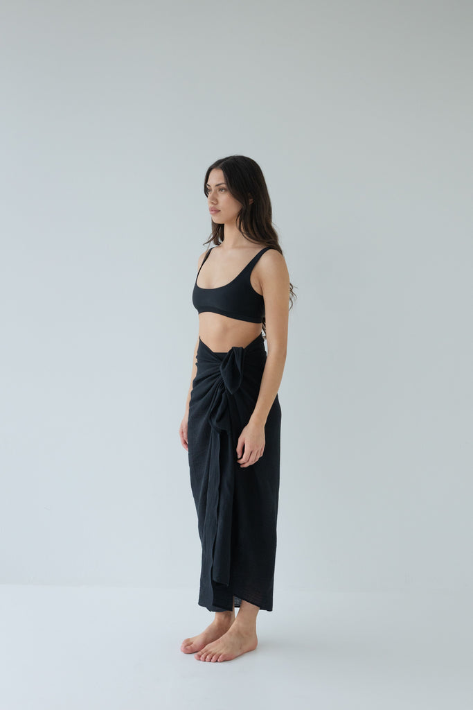 Woman wearing a black sarong and black bikini top
