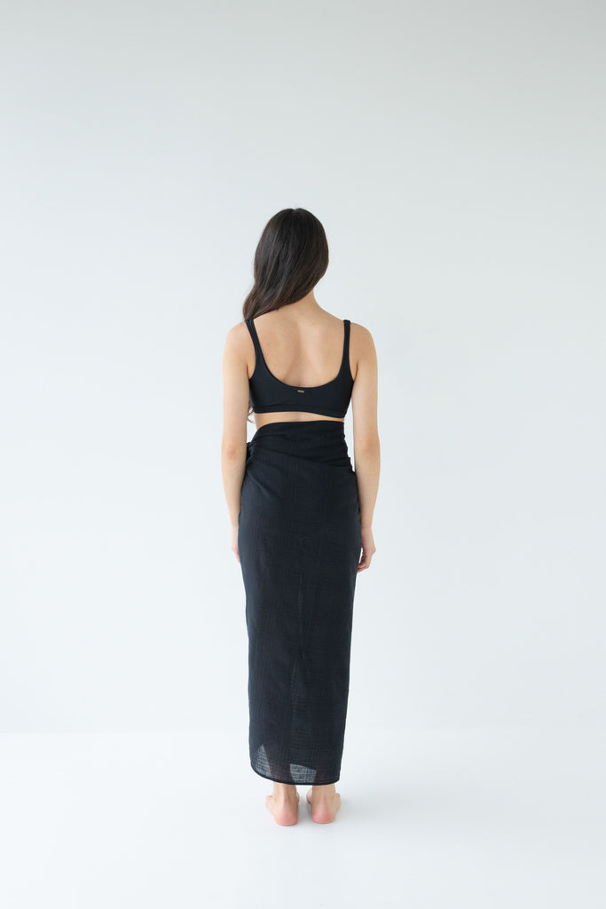 Woman wearing a black sarong and black bikini top