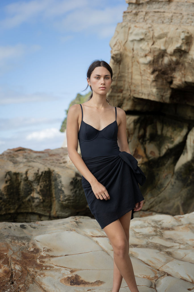 Woman wearing a black sarong and black bikini top