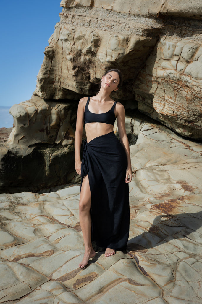 Woman wearing a black sarong and black bikini top