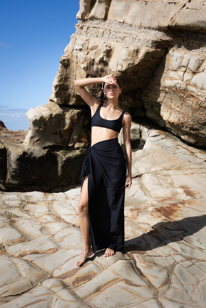 Woman wearing a black sarong and black bikini top