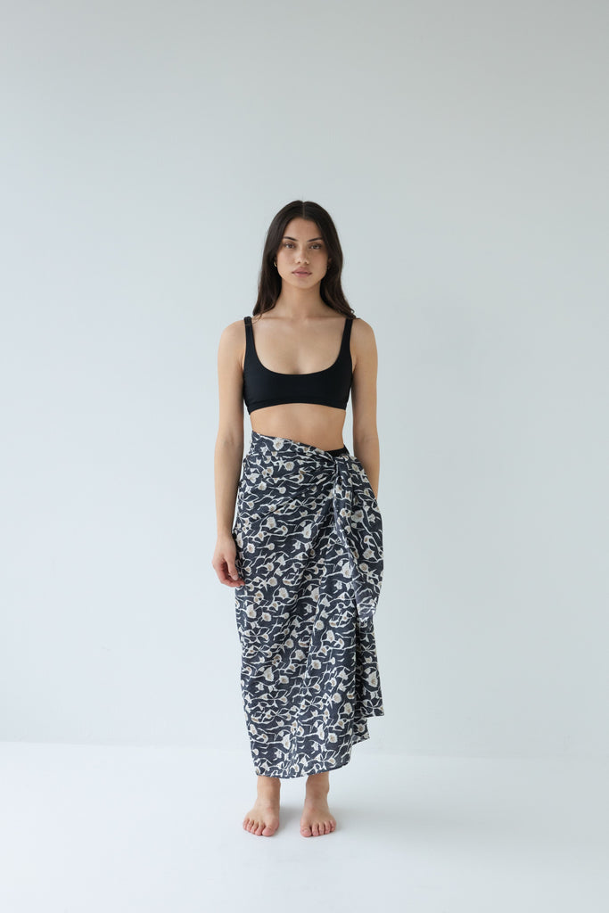 Woman wearing a black top and Sophie Sarong in the floral Coast print